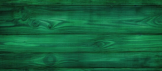 A close-up view of a textured green wood surface, showcasing the intricate patterns and rich colors of the natural material. The wood appears vibrant and lush, with visible grains and knots adding