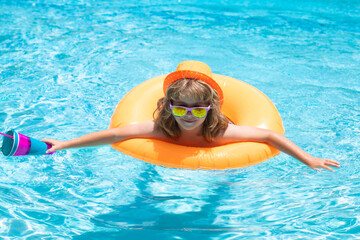 Poster - Summertime fun. Child swimming in pool play with floating ring. Smiling cute kid in sunglasses swim with inflatable rings in pool in summer day.