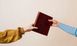 © Lucianastudio - hand of man or woman gives book to friend. Books swap, exchange or crossing.