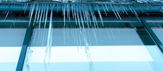 Wall Mural - Icicles hang from a glass building