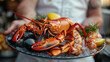Delicious lobster with seafood, crab, mussels, prawns, salmon on a plate in the restaurant.