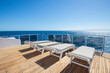 View from stern deck of luxury yacht with sunbeds