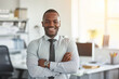 © Ishra - Portrait of a handsome smiling African American businessman at office workplace, professional confident looking young business man at office, positive looking executive manager wearing casual shirt