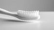 A close up of a single blank white toothbrush on a solid white background.