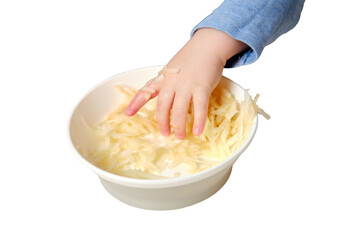 Wall Mural - Funny child eating a grated apple with his hand from a plate, close-up, isolated on white background. Hungry baby boy eats fruit, humor. Kid aged one year and three months