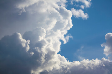 Blue sky with billowy white clouds against a bright blue backdrop