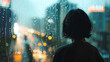 © Ratthamond - The back of an Asian woman with short hair, wearing dark and looking out the window at night at the cityscape view, with raindrops on the glass and blurred street lights