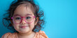 Cute smiling girl with eyewear to vision correction. Banner with blue background and copy space.