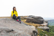 Woman sitting on top of a mountain admiring the view