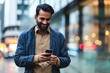 © FrameFlow - Smiling indian business man, eastern businessman holding cell phone using smartphone mobile apps texting message, surfing social media tech standing in urban city on modern street, Generative AI