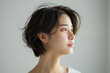 Profile view of a serene Asian woman with short hair against a white background