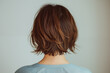 © wazamai - Rear view of a person with a trendy brown short haircut on a neutral background