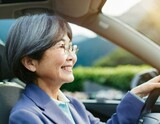 Fototapeta Tulipany - 車を運転する笑顔のシニア女性
