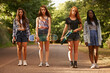 © Jeff B/peopleimages.com - Friends, road and girl with skateboard in woods for hobby with serious look, outdoor and activity in California. Diverse group, teen and leisure on school holiday or break with fun and together.