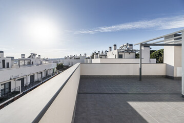 A gray painted metal pergola located on a large empty terrace in the attic of a house