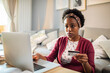 © Davor - Stressed woman using credit card on laptop at home