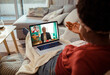 © Davor - Woman having a video call with financial advisor on laptop at home