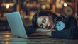 Tired businesswoman sleeping on a laptop with a clock in the background