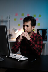 Poster - A man is sitting at a desk with a computer monitor and keyboard in front of him
