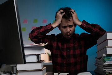 Poster - A man is sitting at a desk with a computer monitor and a stack of books