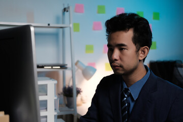 Poster - A man in a suit is sitting in front of a computer monitor