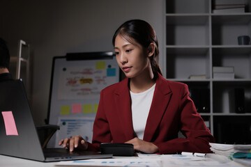 Poster - A woman in a red jacket is typing on a laptop computer