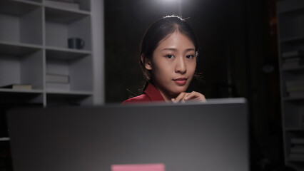 Poster - A woman is sitting in front of a laptop computer