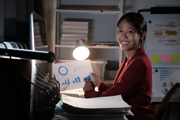 Poster - A woman is sitting at a desk with a computer monitor and a stack of papers
