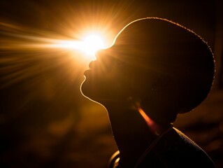 Poster - A silhouette of a person with their head tilted up towards the sun. Concept of peace and serenity as the person looks up at the sun