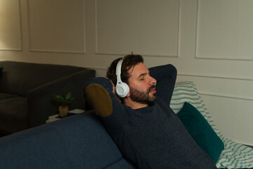 Wall Mural - Handsome man relaxing listening to a guided meditation with headphones