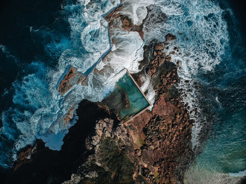 aerial view early morning light with ocean waves flowing over rocks around north curl curl ocean roc