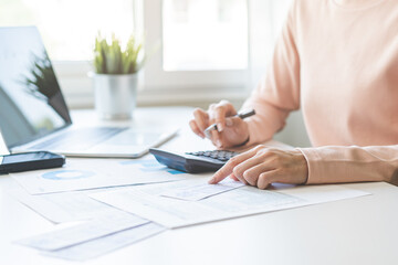 Wall Mural - Deduction planning, debt asian young woman  hand using calculator to calculating  money balance from bill and income, cost budget expenses for pay money form personal individual on table at home.