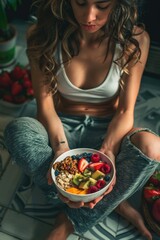 Aufkleber - A woman sitting on the floor holding a bowl of fruit. Suitable for healthy lifestyle concepts