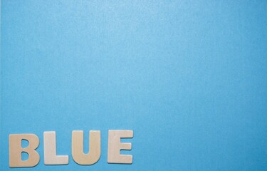 Wooden Letters Spelling Blue on a Blue background