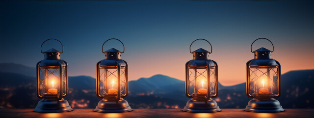 Wall Mural - Four lanterns with candles on a wooden table with a blurred background of a sunset over mountains in the distance.