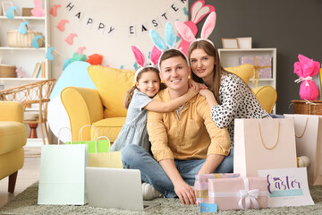 Sticker - Happy family in bunny ears with shopping bags and laptop hugging at home. Easter Sale