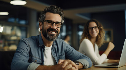 Poster - Smiling businessman sitting in front of team in the office during meeting