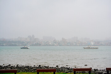 Wall Mural - Bali, New Taipei, Taiwan, Republic of China, 01 22 2024: Cruise ferry boat and port on Clean Tamsui river in a raining day in winter