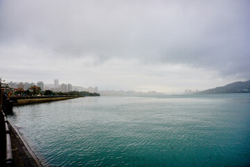 Sticker - Bali, New Taipei, Taiwan, Republic of China, 01 22 2024: Cruise ferry boat and port on Clean Tamsui river in a raining day in winter