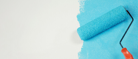 Poster - Roller Brush Painting, Worker painting on surface wall  Painting apartment, renovating with blue color  paint. Leave empty copy space white to write descriptive text beside.