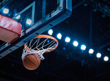 Basketball scoring a basket as it goes through the hoop and making a swish in the net
