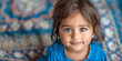 Small cute smiling indian girl over blue textured background. Banner with copy space. Shallow depth of field.
