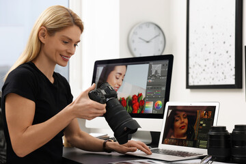 Canvas Print - Professional photographer with digital camera at table in office