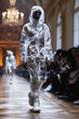 black man model in a transparent cellophane clothes walks down runway at fashion show. Fashion male week