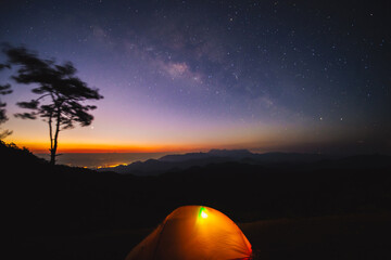 Wall Mural - nature traveling with orange camping tent on mountain with milky way background