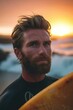 Portrait eines Surfers am Strand bei Sonnenuntergang 