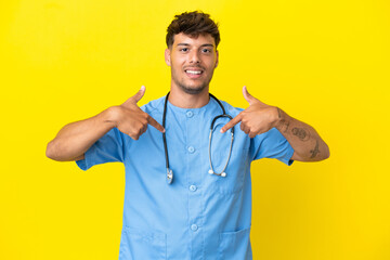 Young surgeon doctor man isolated on yellow background proud and self-satisfied