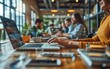 © imagineRbc - Diverse group of people sitting at a table, concentrating on their laptops and working collaboratively