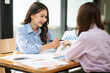 © Thitisak - Asian business woman working and talking at the office