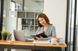 © Thitisak - Asian businesswoman holding notebook about business, spending money